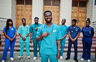 Group of african medical students posed outdoor against university door.